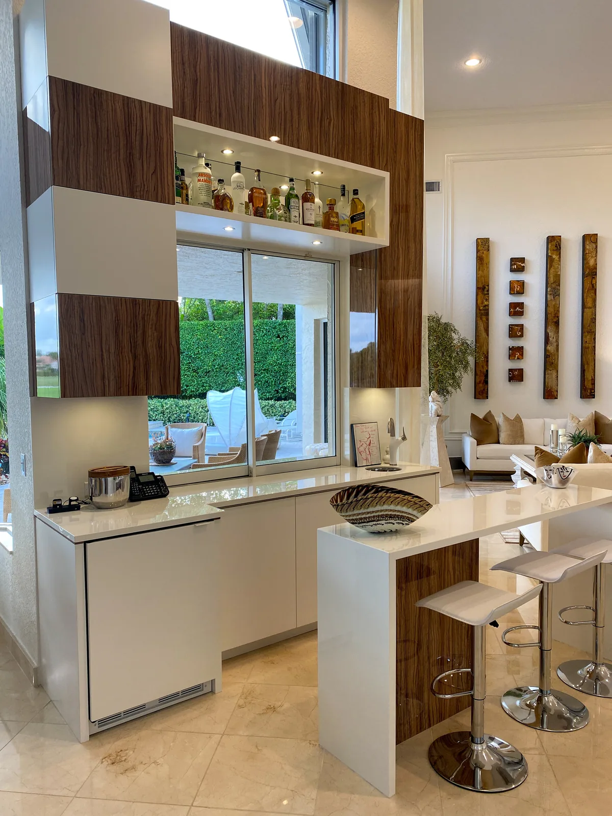 Custom bar in high-gloss Macassar ebony and white lacquer with a pass-through window to the patio