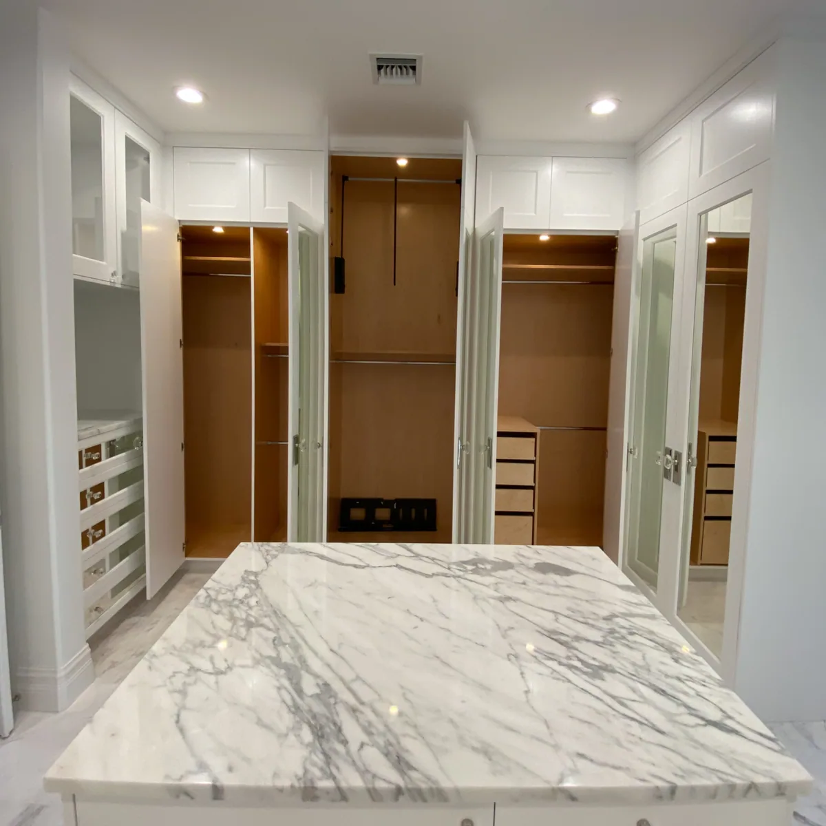Custom dressing room with a marble-topped island and cedar-lined wardrobes, Palm Beach County residence, Jupiter FL