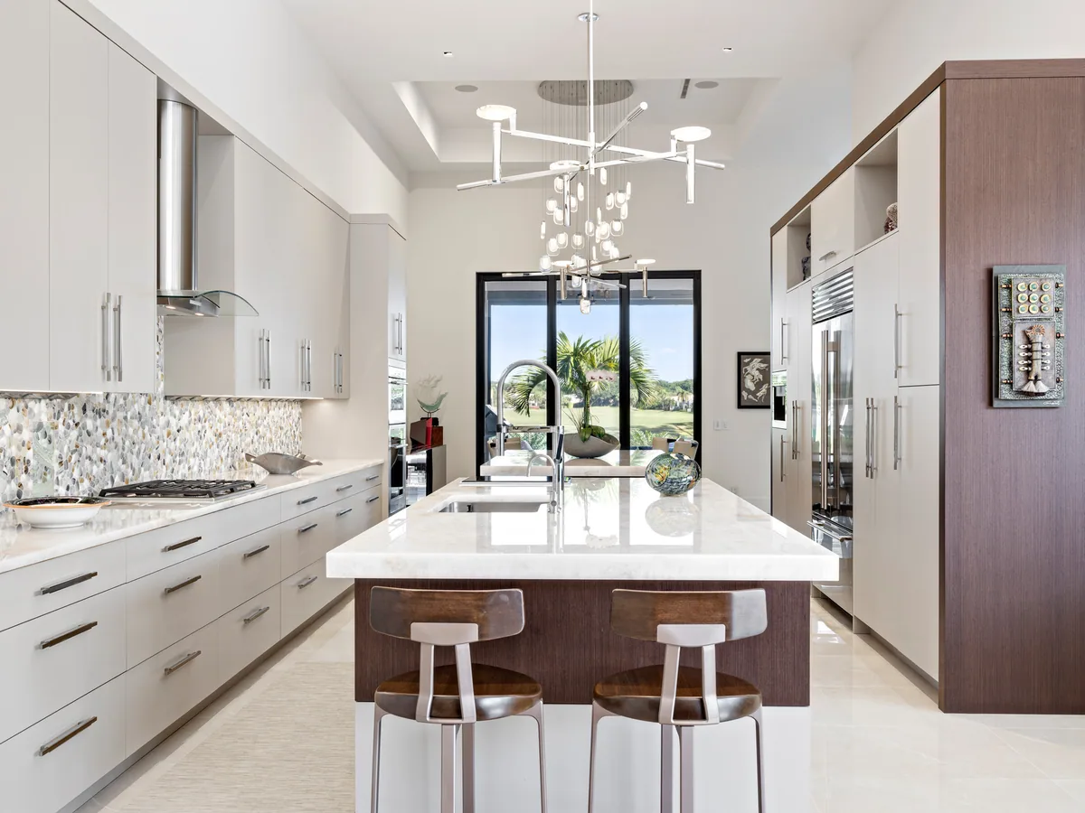 Contemporary flat-panel custom kitchen with a quartz waterfall island, Palm Beach County residence, Jupiter FL