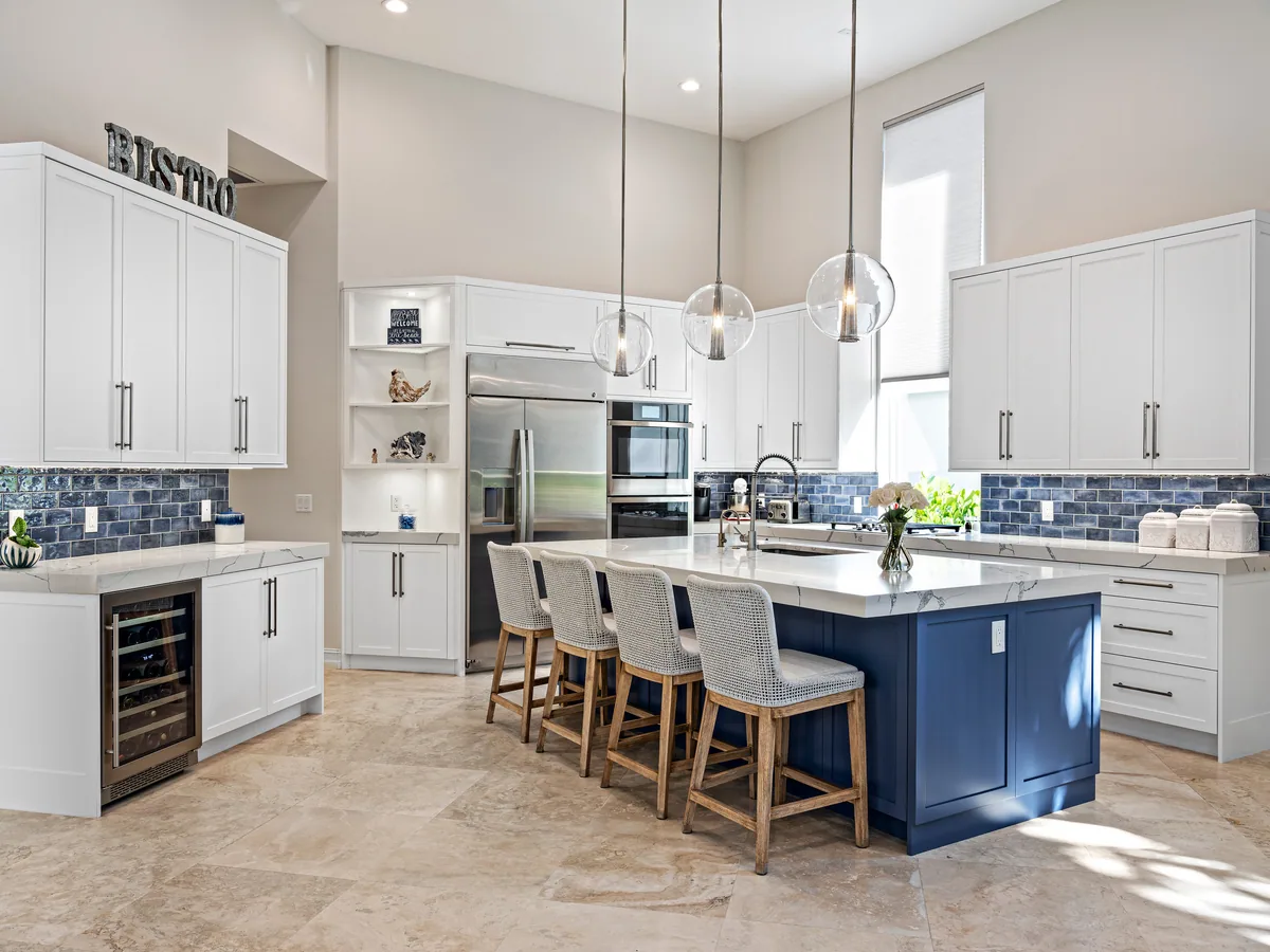 Custom kitchen with white shaker cabinetry and a navy painted island, Palm Beach County residence, Jupiter FL