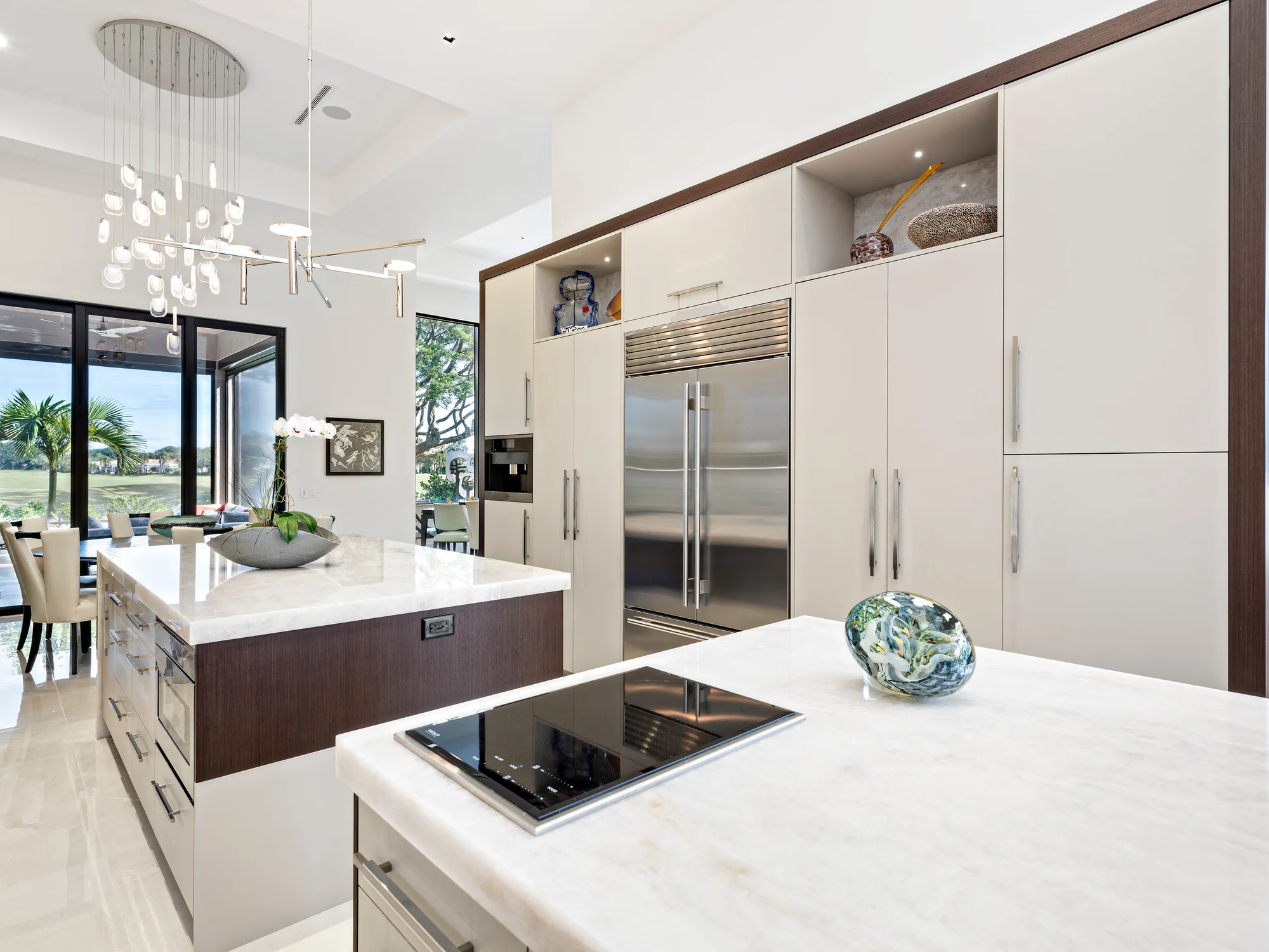 Custom kitchen with flat-panel cabinetry and a walnut waterfall island, Palm Beach County residence, Jupiter FL