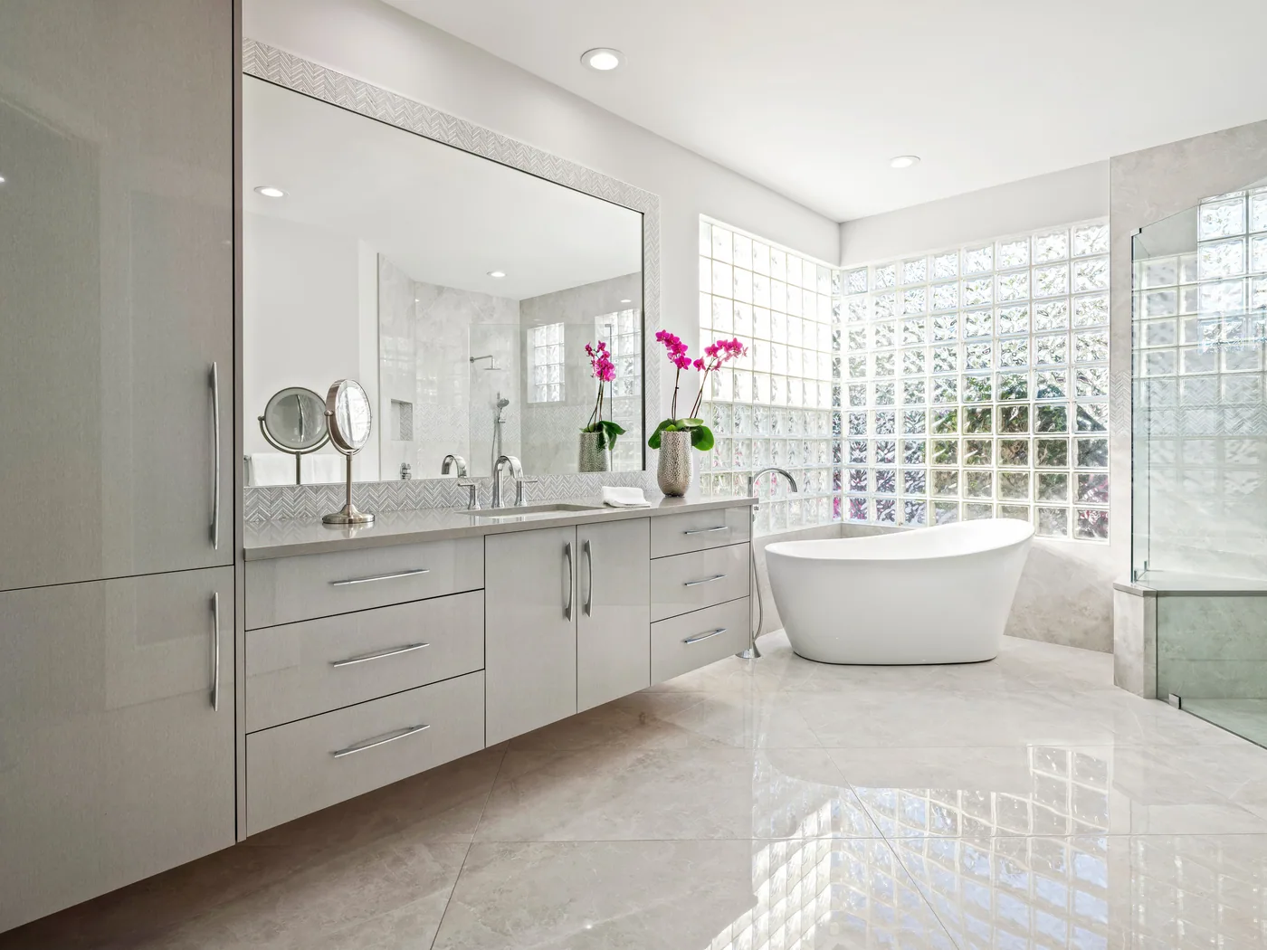 Custom primary bath with a full-wall double vanity and freestanding tub, Palm Beach County residence, Jupiter FL