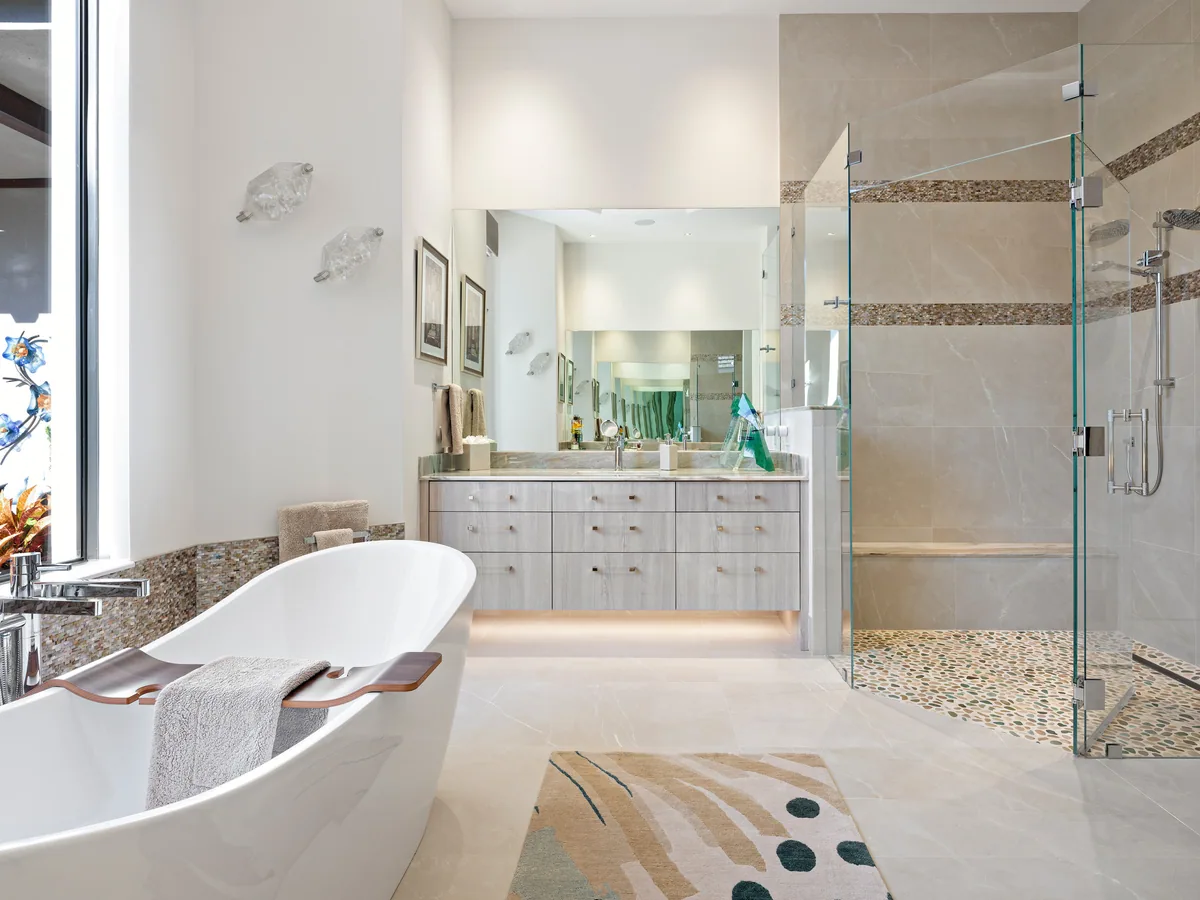 Custom primary bath with a cerused oak vanity on under-cabinet lighting, freestanding tub and glass walk-in shower, Palm Beach County residence, Jupiter FL